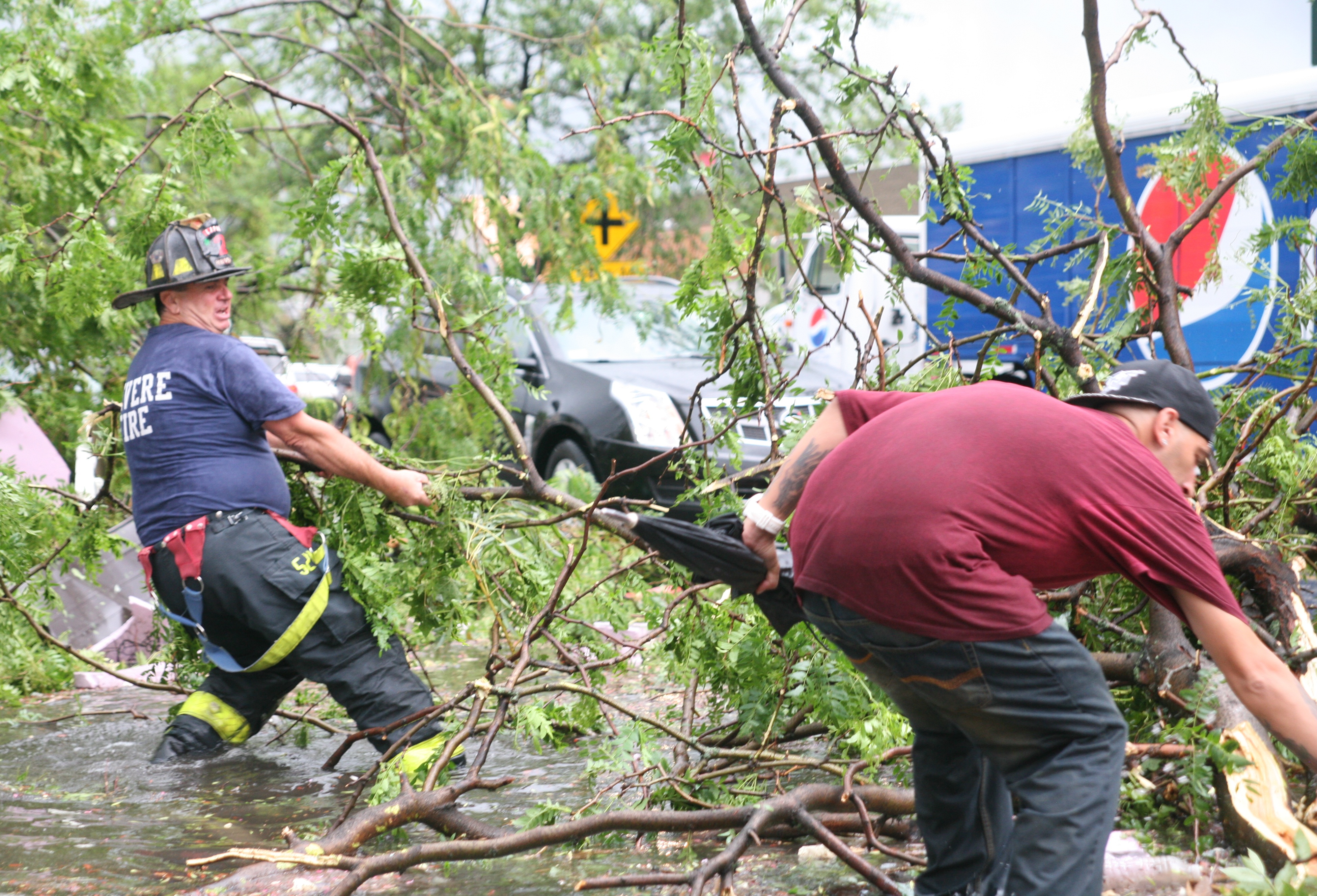 A Revere Firefighter and a passer-by struggled to pull trees off of Broadway about 45 minutes after the hit.