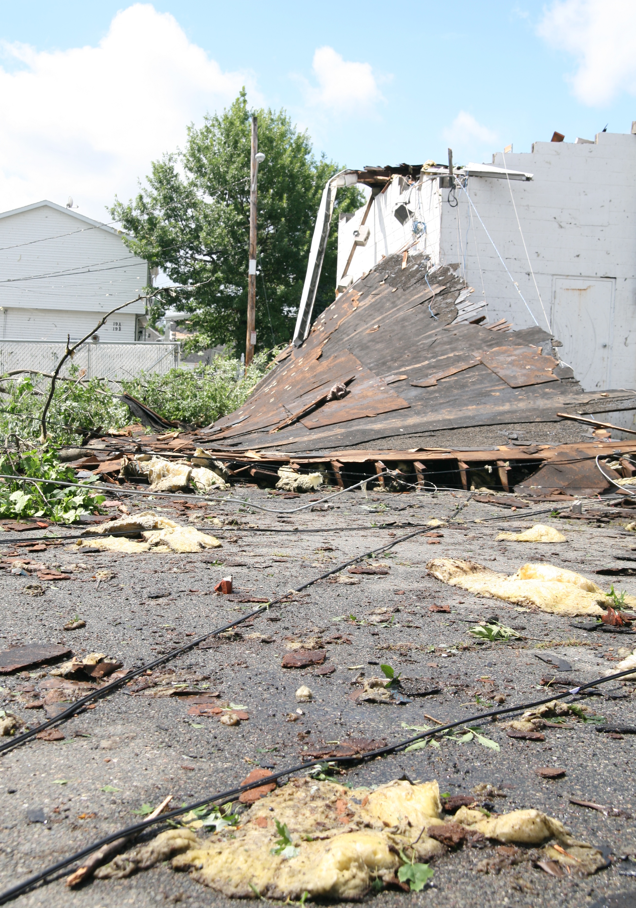 The roof was ripped off of the Curley building – which houses an auto body shop on lower Broadway. Electrical wires are all over the ground as well.