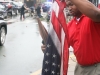 Broadway Attorney Dan Occena picks up a soiled and soaked American flag that an hour earlier hung proudly from the lightposts. Several bystanders picked up the flags out of respect from the debris in the first hour after the tornado.